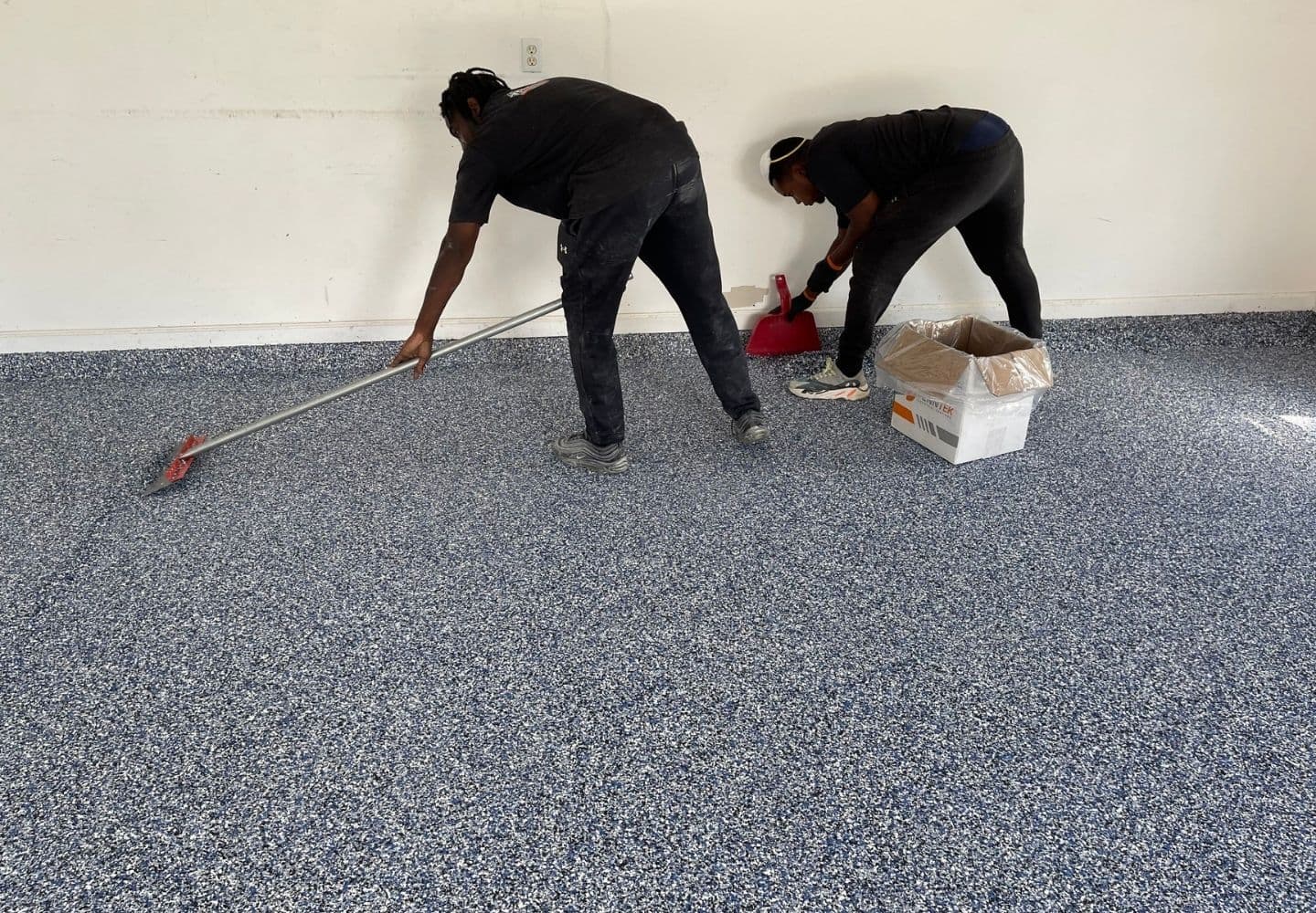 A professional Floortek Coatings crew installing a grey flake polyaspartic floor in an Orange County garage.